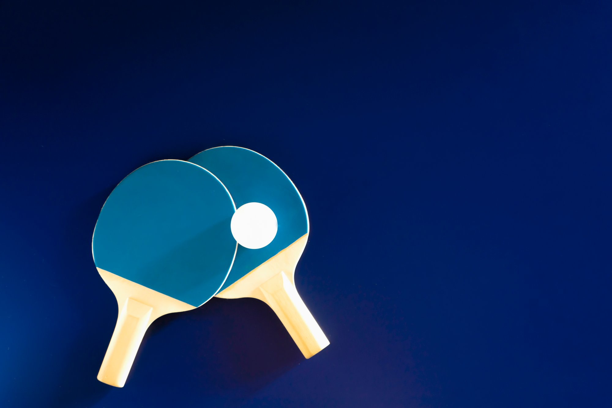 duas-raquetes-de-tenis-de-mesa-repousam-sobre-uma-mesa-de-tenis-prontas-para-as-competicoes